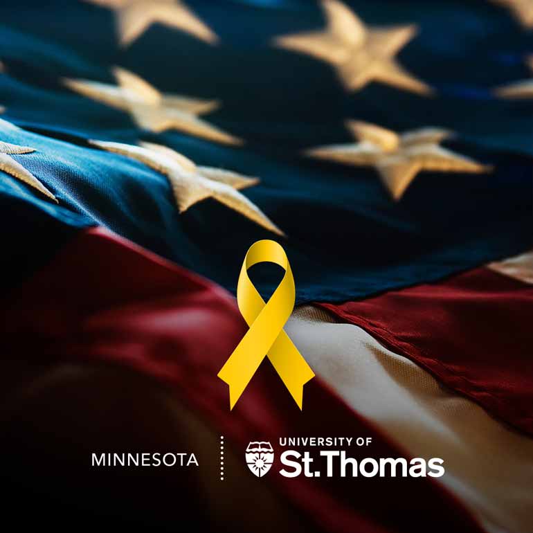 A yellow ribbon lies in front of the American Flag and the St. Ҵý logo is at the bottom.